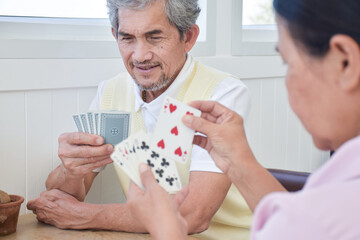 Card playing of elderly people at home in their freetimes, recreation and happiness of elderly people concept.