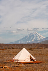 Glamping house and volcano, rural landscape, tent houses in Kamchatka peninsula. Selective focus.