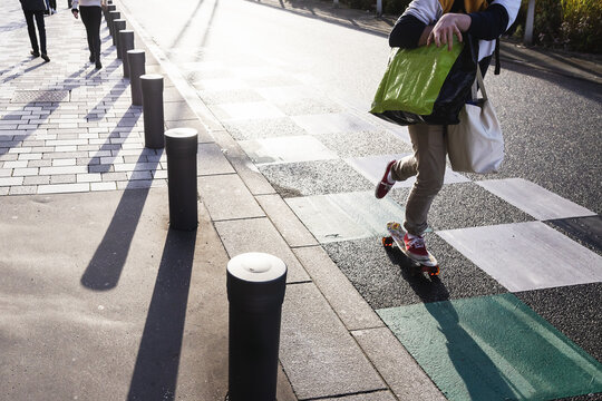 young person with shopping bags on a skateboard