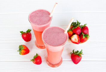 Strawberry yogurt fruit juice smoothie pink colorful fruit juice milkshake blend beverage healthy high protein the taste yummy In glass drink episode morning on white wood background.