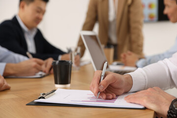 Businesswoman having meeting with her employees in office, closeup