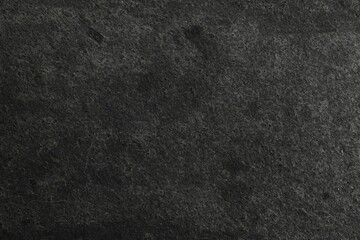 Texture of dark grey stone surface as background, closeup