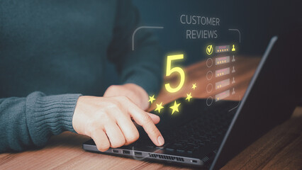 Businessman hand using computer laptop with popup five star icon for feedback review satisfaction...