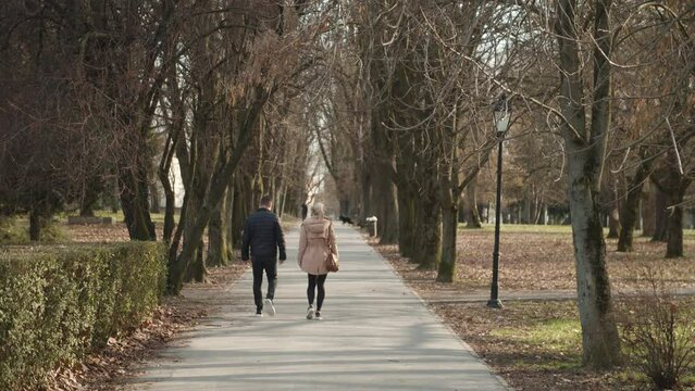 A woman and a man are walking in the park. Slow motion 50fps.