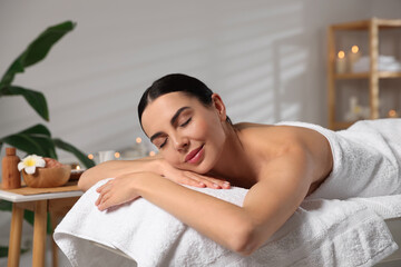 Obraz na płótnie Canvas Beautiful woman relaxing on massage table in spa salon