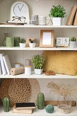 White shelving unit with plants and different decorative stuff