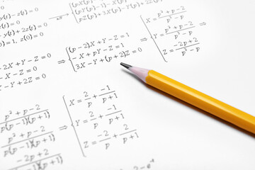 Sheet of paper with mathematical formulas and pencil, closeup
