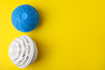 Laundry dryer balls on yellow background, flat lay. Space for text
