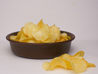 Cassava chips in a brown bowl isolated on a white background