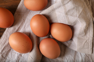 Raw brown chicken eggs on wooden table, flat lay