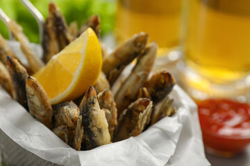 Delicious fried anchovies, lemon and sauce, closeup view