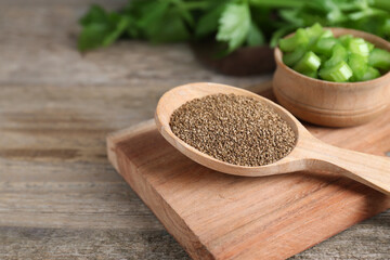 Spoon of celery seeds on wooden table, closeup. Space for text