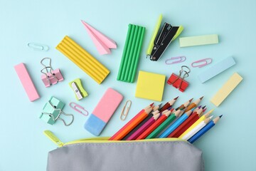 Flat lay composition with school stationery on light blue background. Back to school