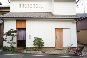 Japan minimalist style design house with white wall and wooden door. Red