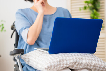 車椅子でノートパソコンを使う若い女性　多様性社会イメージ	