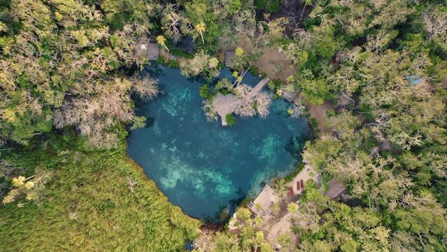Rising drone shot from Cenote Corazon, a private heart-shaped body of water in Mexico.