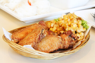 Fried chicken with fish sauce and fried corn arranged in a basket on the table. Selective focus