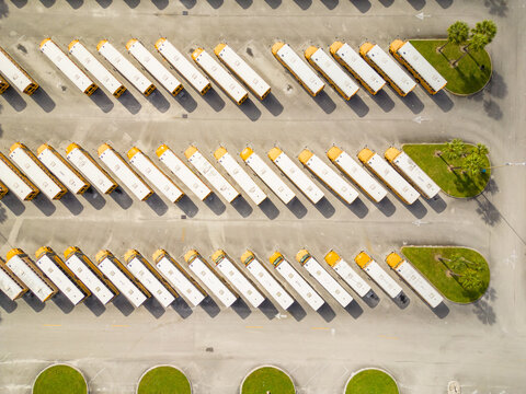 Aerial overhead photo of school busses in a parking lot idle for winter break