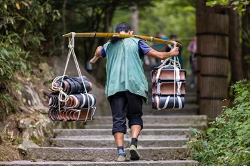 Photo sur Plexiglas Monts Huang A picker carrying shingles on Mount Huangshan