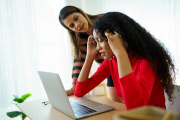 Unhappy - worried young woman expressing an unwell face in front of the notebook computer and her...