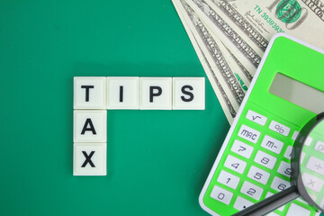 magnifying glass, paper money and calculator with the word tax tips alphabet. tax tip concept