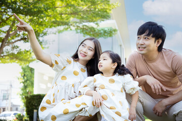 Family Asian. Happy young family of three smiling while spending free time outdoors. Asian family of mother and father learning with daughter on vacation outside.