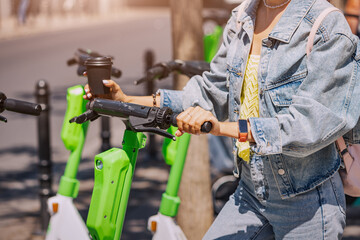 girl rents an electric scooter for move around the city. Choose eco transport and contemporary mobility