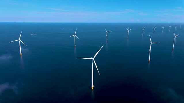 Offshore windmill park with clouds and a blue sky, windmill park in the ocean aerial view with wind turbine Flevoland Netherlands Ijsselmeer