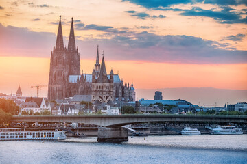 Cologne view with bridge over the Rhine River. Majestic Cologne Cathedral in the background. Colorful sunset sky. Travel sights of Germany © EdNurg