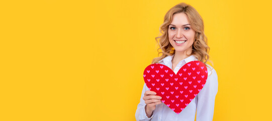 smiling woman with red love heart on yellow background. Woman isolated face portrait, banner with...