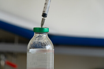 Syringe inside saline in the infirmary. Close up.