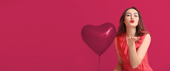 Beautiful young woman with balloon blowing kiss on color background with space for text. Valentine's Day celebration