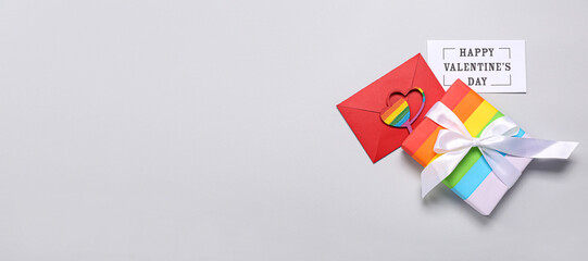 Card with text HAPPY VALENTINE'S DAY, gift and letter on grey background with space for text. LGBT concept