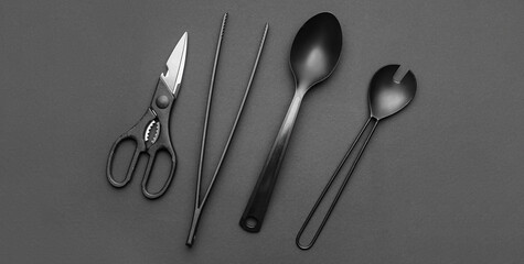 Kitchen utensils on dark background, top view