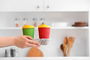 Female hand with paper cup holder on kitchen