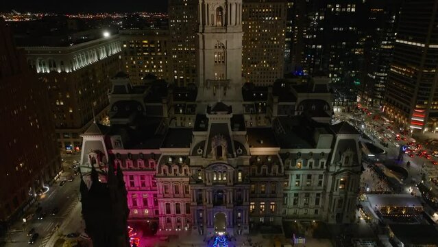 Philadelphia City Hall. Rising aerial reveal from Christmas tree and decorated with lights to night view of city.
