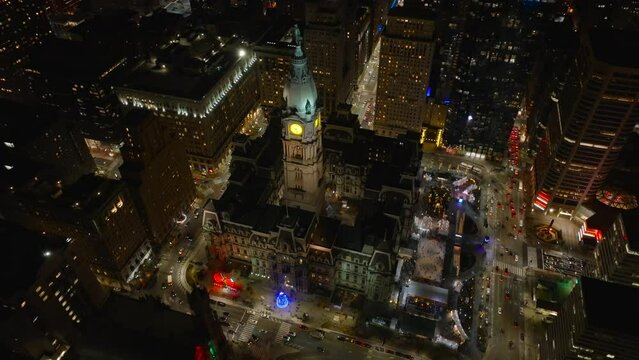 Philadelphia City Hall at night. Aerial establishing shot of Philly with Christmas tree and lights at night. Drone view in darkness.