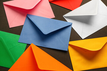 Many different paper envelopes on dark background, closeup