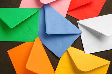 Many different paper envelopes on dark background, closeup