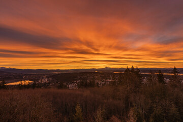 Vivid orange sunrise over a BC valley on a winter morning.