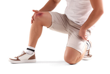 Man with bruise on knee against white background