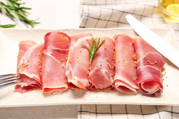 Plate with slices of tasty ham on light table, closeup