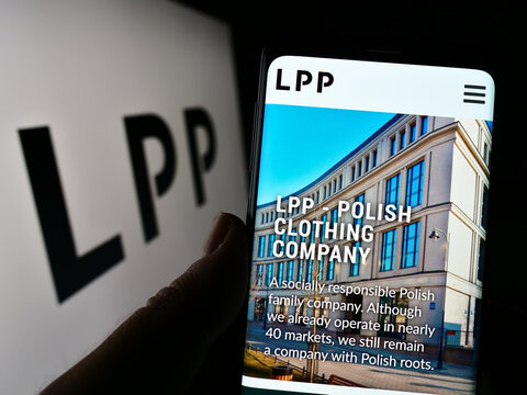 Stuttgart, Germany - 12-25-2022: Person holding smartphone with website of Polish clothing retail company LPP S.A. on screen in front of logo. Focus on center of phone display.