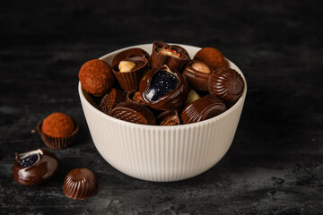 White bowl with chocolate candies on dark table
