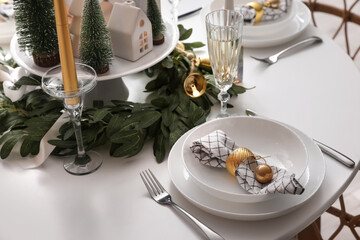 Christmas table setting with candle holders and wreath in kitchen, closeup