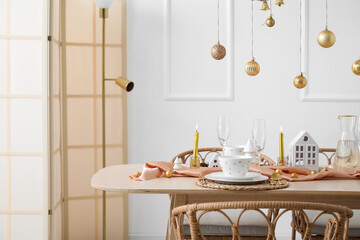Table setting with candle holders and Christmas balls in dining room
