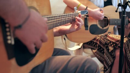 two hippie musicians perform concert on guitar, one in foreground, slow motion