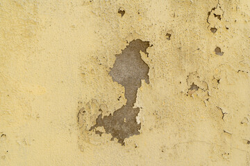 House paint peels off the building walls, yellow color painted peeling wall background, Old cracked wall, dirty grunge texture.