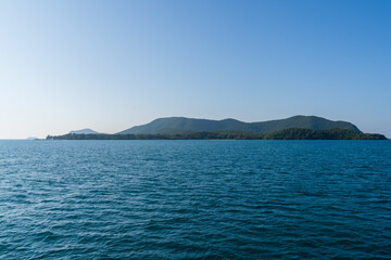 Naklejka premium Natural landscape of green island and blue sea. Clear blue water, overlooking the wide sea, beautiful blue sea waves, Panoramic view of blue calm ocean.
