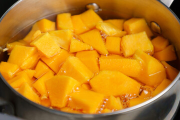 Cooking pumpkin in water, pumpkin soup. Diet soup in a pot. Selective focus.